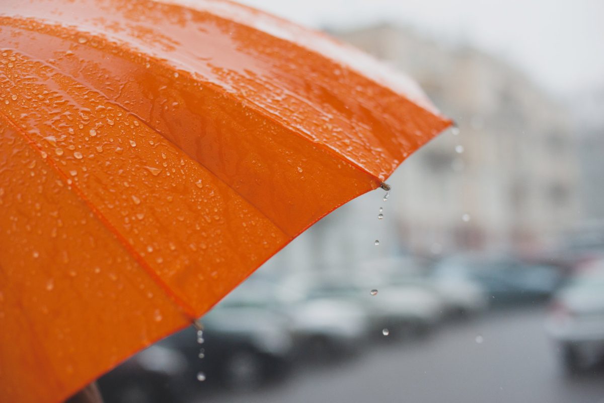 rain drops falling from a bright orange umbrella